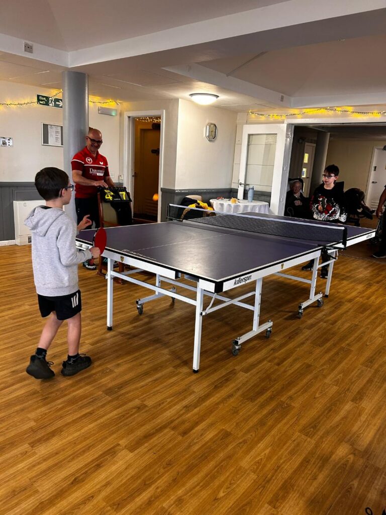 children playing table tennis on a care home visit